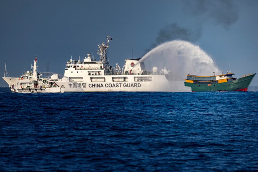 Un barco de la Guardia Costera china lanza un cañón de agua contra el Unaizah May 4, embarcación fletada por la Marina filipina, durante una misión de reabastecimiento en el banco de arena Second Thomas Shoal, en el Mar de China Meridional, el 5 de marzo de 2024. El incidente dejó cuatro filipinos con heridas leves. (Ezra Acayan/Getty Images).