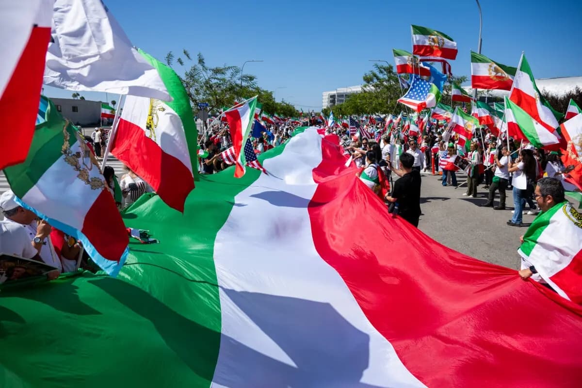 La gente porta una bandera iraní gigante durante una protesta en respuesta a la prohibición de la FIFA de la bandera pre-revolucionaria de Irán dentro de los estadios de la Copa del Mundo en Inglewood, California, el 7 de junio de 2026. (Benjamin Hanson/AP)