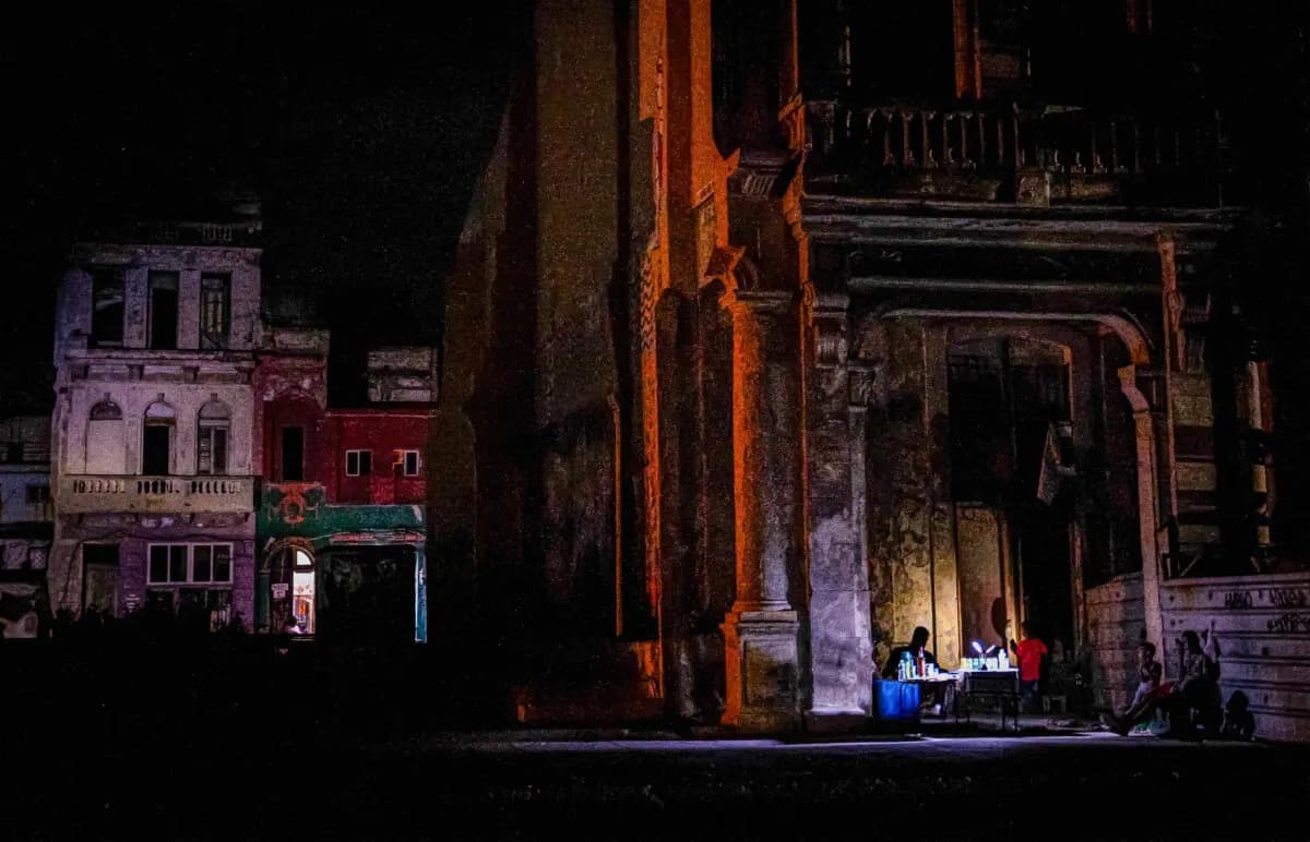 Varias personas se reúnen frente a un edificio durante un apagón en La Habana el 16 de marzo de 2026. (Adalberto Roque/AFP vía Getty Images).