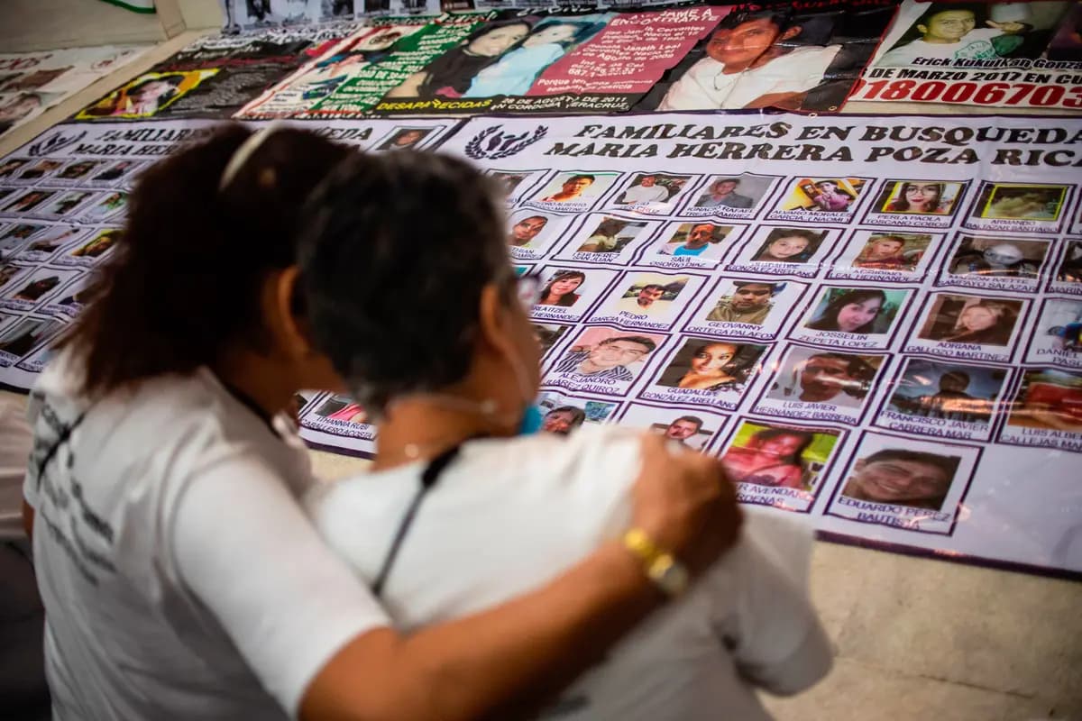 Unas mujeres observan retratos de personas desaparecidas en Huitzuco de los Figueroa, México, el 20 de enero de 2019. (Pedro Pardo/AFP vía Getty Images).
