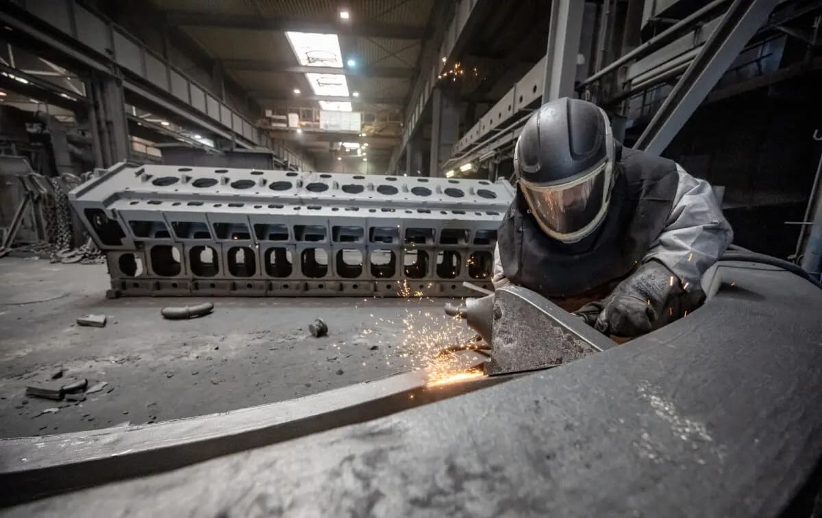Un trabajador desbarba una pieza fundida en la fundición Siempelkamp Giesserei en Krefeld, Alemania, el 21 de abril de 2022. (Sascha Schuermann/Getty Images)