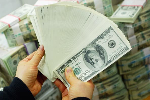 Un banquero surcoreano transporta billetes de dólares estadounidenses en el banco Korea Exchange el 22 de febrero de 2005 en Seúl, Corea del Sur. (Chung Sung-Jun/Getty Images).