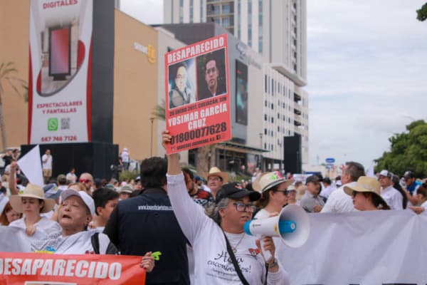 <em>Manifestantes de “Culiacán Valiente” protestan en la capital de Sinaloa, México, el 29 de septiembre de 2024. Los manifestantes exigían paz tras tres semanas de violencia. Al frente estaban las madres buscadoras con fotografías de sus hijos desaparecidos. En la Fiscalía General del Estado se instaló un altar en honor a Juan Carlos, un joven que murió durante un enfrentamiento entre civiles armados, junto con fotografías de personas desaparecidas. (Ivan Medina/AFP vía Getty Images)</em>