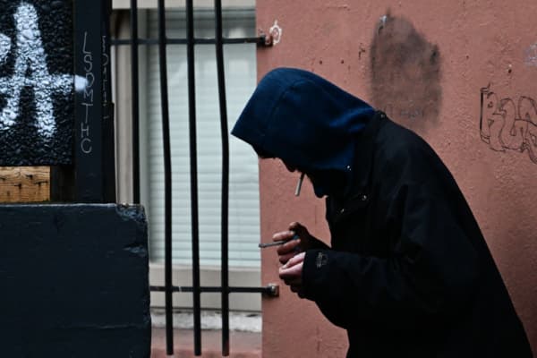 <em>Una persona sostiene carrillos en su mano y boca tras la despenalización de todas las drogas, incluido el fentanilo y la metanfetamina, en el centro de Portland, Oregón, el 25 de enero de 2024. (Patrick T. Fallon/AFP vía Getty Images)</em>