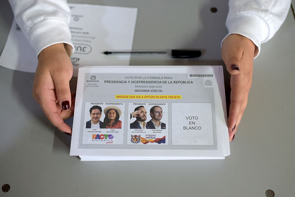<em>Una trabajadora sostiene material electoral en un colegio electoral durante la segunda vuelta de las elecciones presidenciales, en Bogotá el 21 de junio de 2026. Los colombianos votaron para elegir un nuevo presidente entre un abogado de extrema derecha respaldado por la Casa Blanca y un senador de izquierda que decidirá el destino del tambaleante proceso de paz del país y los tensos lazos con Washington. (Sebastián BARROS/AFP vía Getty Images)</em>