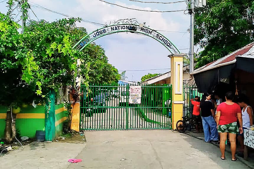 Varias personas se encuentran junto a la puerta de entrada de la Escuela Secundaria Nacional San José tras un tiroteo ocurrido en la ciudad de Tacloban, provincia de Leyte, el 22 de junio de 2026. Al menos tres estudiantes adolescentes murieron y otros siete resultaron heridos el 22 de junio en un inusual tiroteo escolar en el centro de Filipinas, según informó la policía. (Noel Sianosa / AFP vía Getty Images)