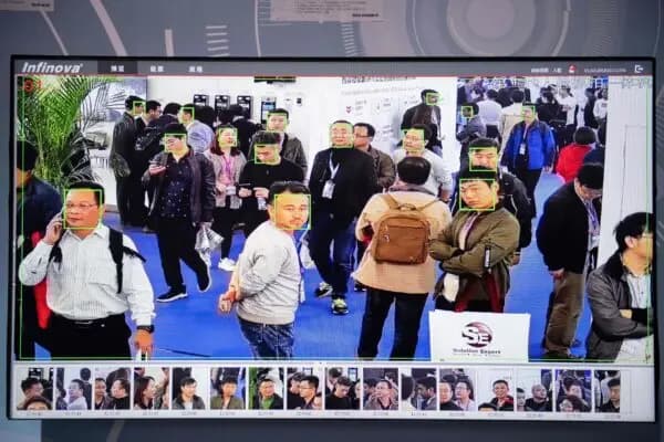<em>Una pantalla muestra visitantes siendo grabados por cámaras de seguridad con inteligencia artificial y tecnología de reconocimiento facial en la 14.ª Exposición Internacional de China sobre Seguridad Pública, en el Centro Internacional de Exposiciones de China en Beijing el 24 de octubre de 2018. (Nicolas Asfouri/AFP vía Getty Images)</em>