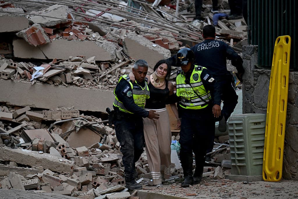 Agentes de la policía municipal evacuan a una víctima herida de un edificio derrumbado tras un terremoto en Caracas el 24 de junio de 2026. Los temblores obligaron a los habitantes de Caracas a salir a las calles. (Juan Barreto / AFP vía Getty Images) 