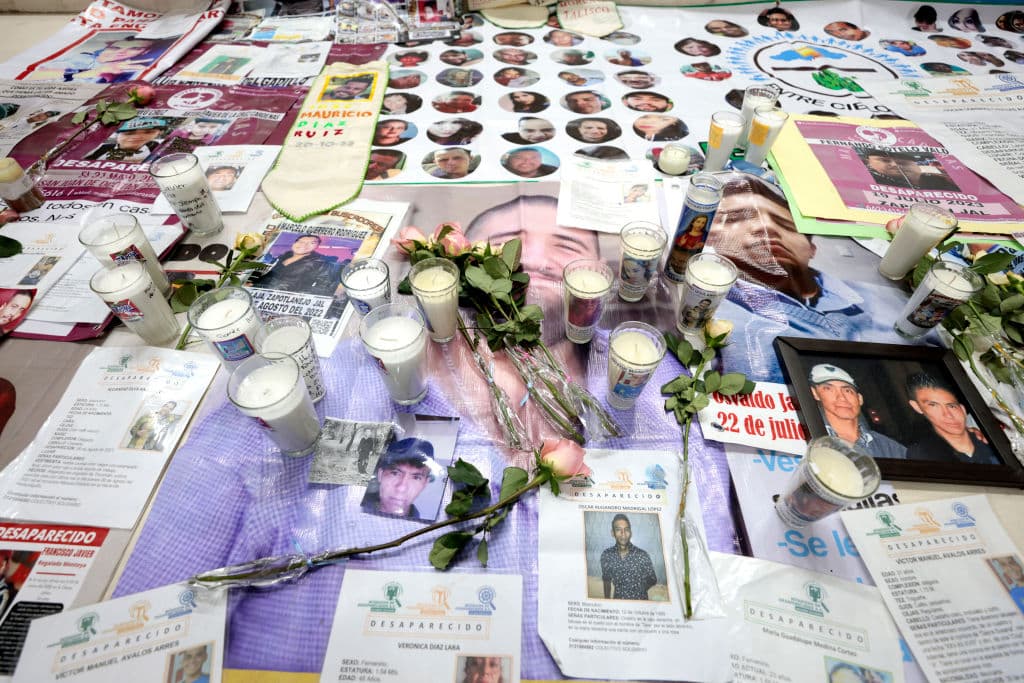 En una iglesia se exhiben imágenes de personas desaparecidas durante una jornada de oración en Teuchitlán, estado de Jalisco, México, el 16 de marzo de 2025. Los participantes marcharon para exigir justicia tras el macabro hallazgo de restos óseos calcinados, zapatos y prendas de vestir en un presunto centro de adiestramiento de un cártel del narcotráfico. (Ulises Ruiz / AFP vía Getty Images)