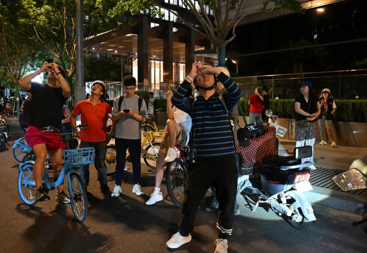 <em>Varias personas toman fotografías de la Torre CITIC en Beijing el 26 de junio de 2026. (Adek Berry/AFP vía Getty Images).</em>
