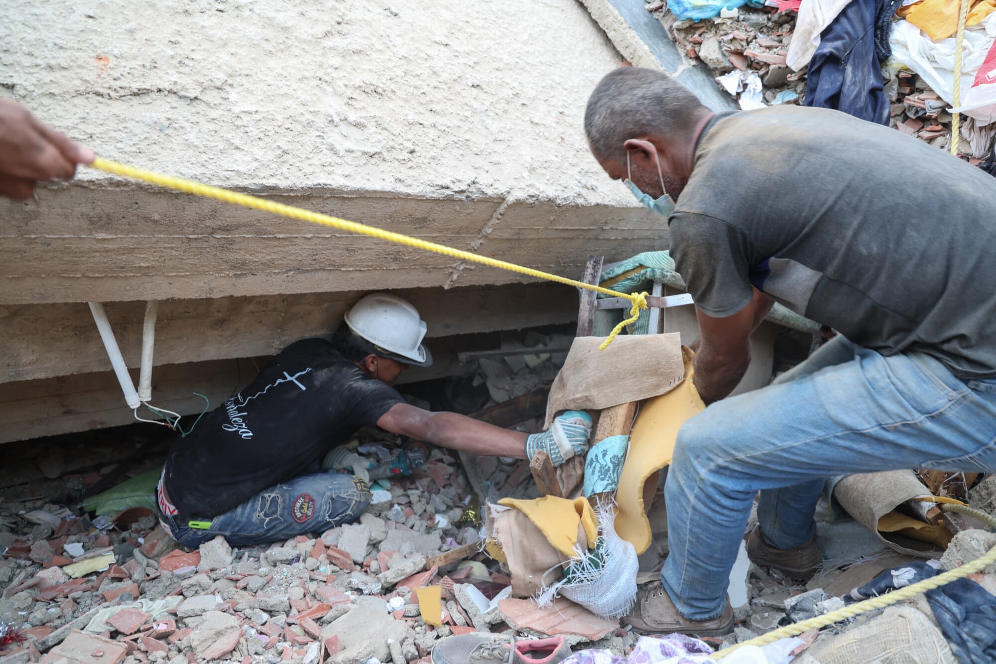 La población y los equipos de rescate buscan a las víctimas entre los escombros de un edificio derrumbado en Catia La Mar, el 26 de junio de 2026 en La Guaira, Venezuela, tras los terremotos de magnitud 7.2 y 7.5 que sacudieron Venezuela y otras regiones del Caribe. (Edilzon Gamez/Getty Images)