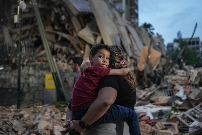 Personas pasan caminando junto a un edificio colapsado tras un terremoto en Caracas el 25 de junio de 2026. (Manaure QUINTERO / AFP via Getty Images)