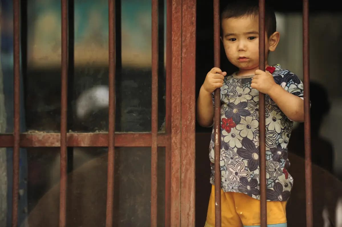 Un niño uigur mira desde su casa en Urumqi, en la región china de Xinjiang, el 12 de julio de 2009. (Peter Parks/AFP vía Getty Images)