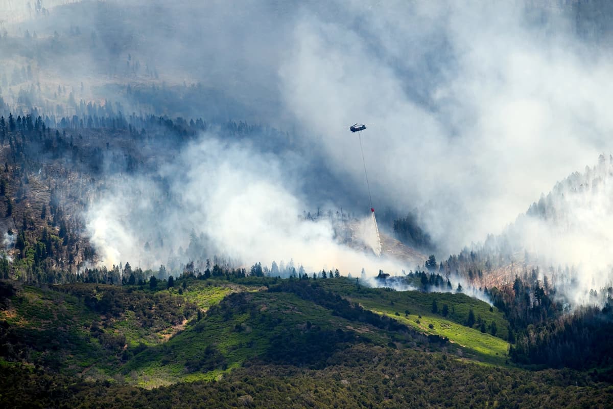 Un helicóptero arroja agua sobre el incendio Cottonwood, que arde cerca de Beaver, Utah, el sábado 27 de junio de 2026. (Foto AP/Noah Berger)