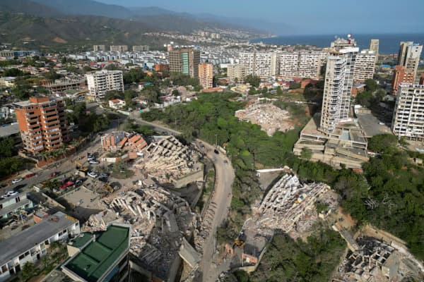 <em>Vista aérea que muestra edificios derrumbados en Catia La Mar, estado La Guaira, Venezuela, el 27 de junio de 2026, tras los terremotos que golpearon la región. Autoridades y equipos de emergencia trabajan entre los escombros mientras crece la preocupación por las personas desaparecidas y la falta de ayuda oficial rápida para rescatar a los sobrevivientes. (Federico PARRA / AFP vía Getty Images)</em>
