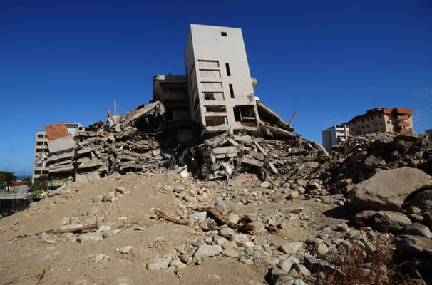 <em>Edificios destruidos en la región costera de La Guaira, estado Vargas, a 50 km de Caracas, el 11 de diciembre de 2009. Los Corales fue una de las zonas más afectadas durante las inundaciones del 15 y 16 de diciembre de 1999, que dejaron alrededor de 10,000 muertos. (Foto de Juan Barreto/AFP vía Getty Images)</em>