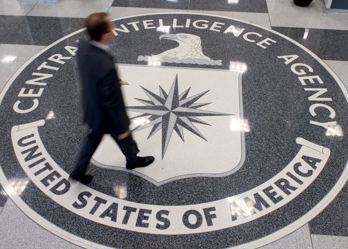 Un hombre cruza el escudo de la Agencia Central de Inteligencia (CIA) en el vestíbulo de la sede de la CIA en Langley, Virginia, el 14 de agosto de 2008. (Saul Loeb/AFP vía Getty Images).