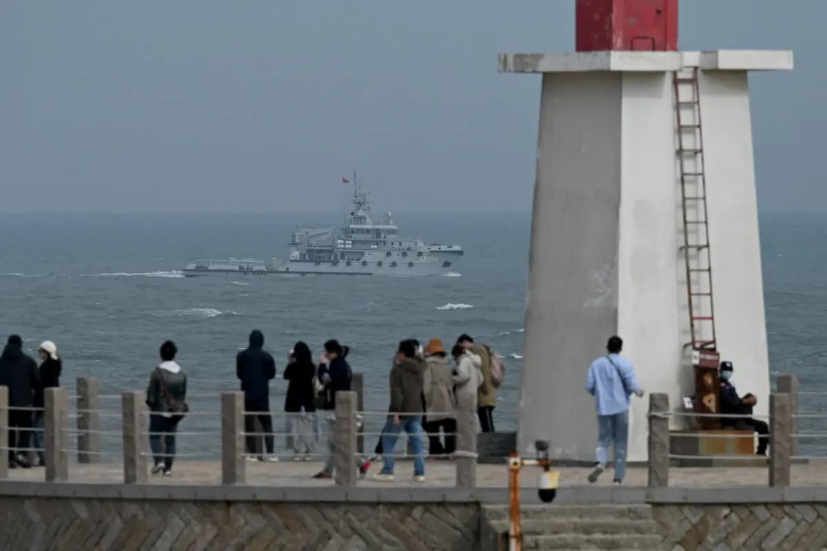 <em>Un remolcador de la armada china navega por el estrecho de Taiwán, pasando junto a turistas en la isla de Pingtan, el punto más cercano a Taiwán, en el sureste de la provincia de Fujian, China, el 7 de abril de 2023. (Greg Baker/AFP vía Getty Images).</em>