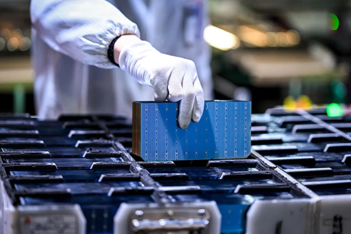 Un trabajador sostiene una pieza de módulos fotovoltaicos para paneles solares en una fábrica de Suqian, provincia de Jiangsu, China, el 23 de enero de 2025. (STR/AFP vía Getty Images)