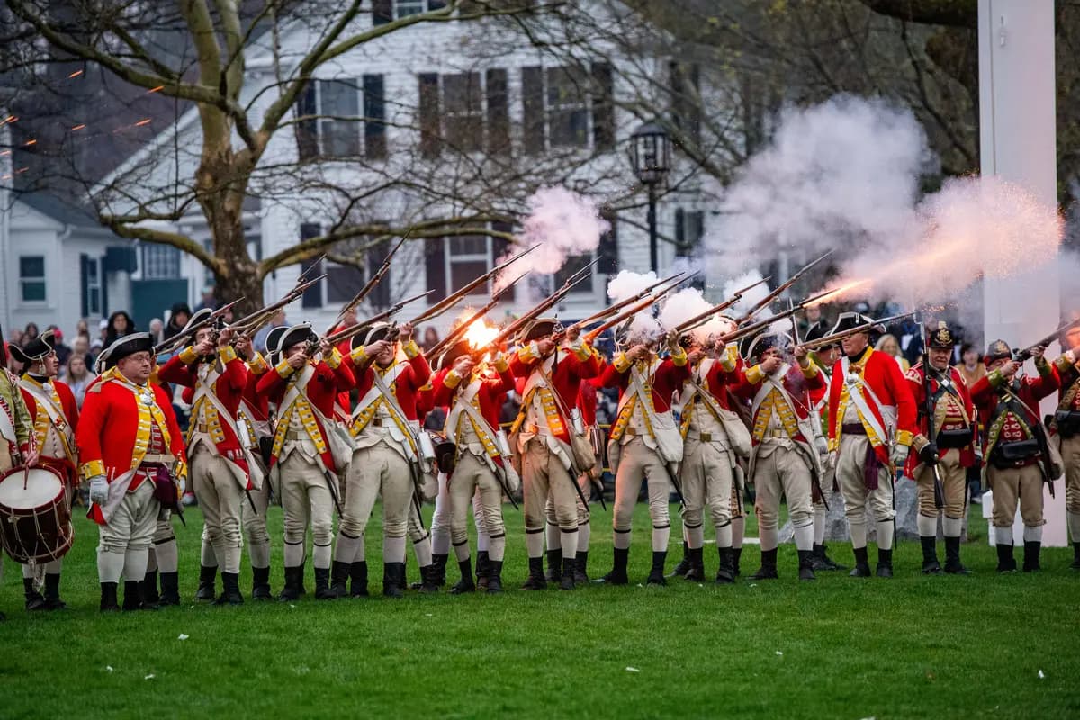 Recreadores vestidos como soldados británicos disparan durante una recreación de la Batalla de Lexington y Concord, como parte de las celebraciones del Día de los Patriotas en Lexington, Massachusetts, el 18 de abril de 2026. (Joseph Prezioso/AFP vía Getty Images)