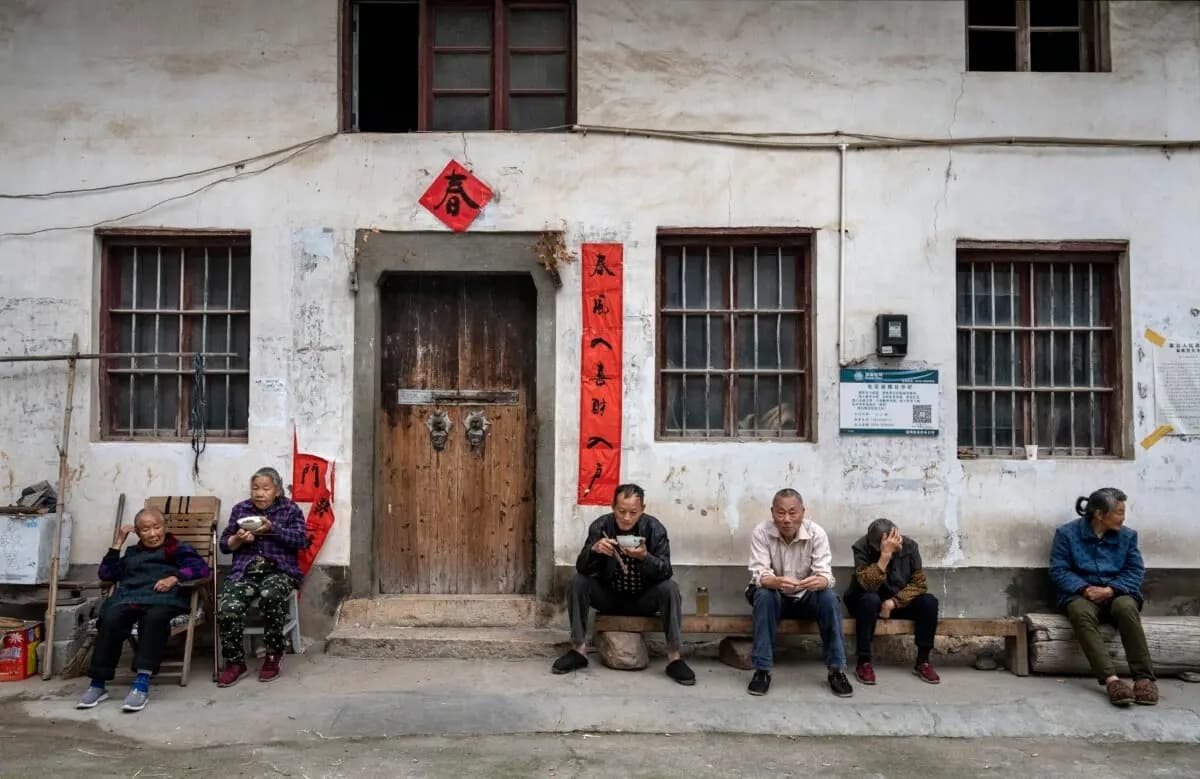 Los habitantes de una aldea comen juntos frente a una casa local en una comunidad agrícola del condado de She, provincia de Anhui, China, el 12 de mayo de 2023. (Kevin Frayer/Getty Images)