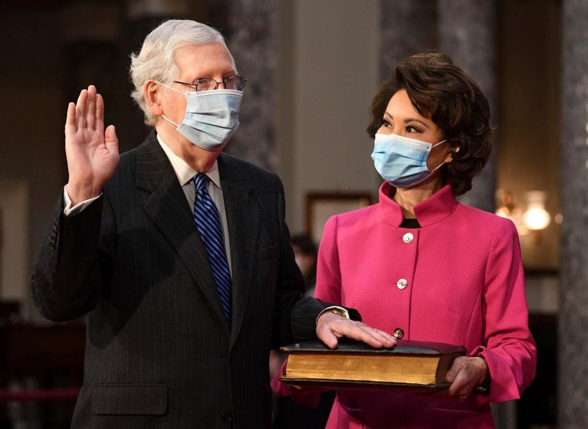 El senador Mitch McConnell (R-Ky.) participa en una ceremonia simbólica de juramento mientras su esposa, la secretaria de Transporte Elaine Chao, sostiene una Biblia, en la Antigua Cámara del Senado del Capitolio en Washington, el 3 de enero de 2021. (Kevin Dietsch/Pool vía AP)