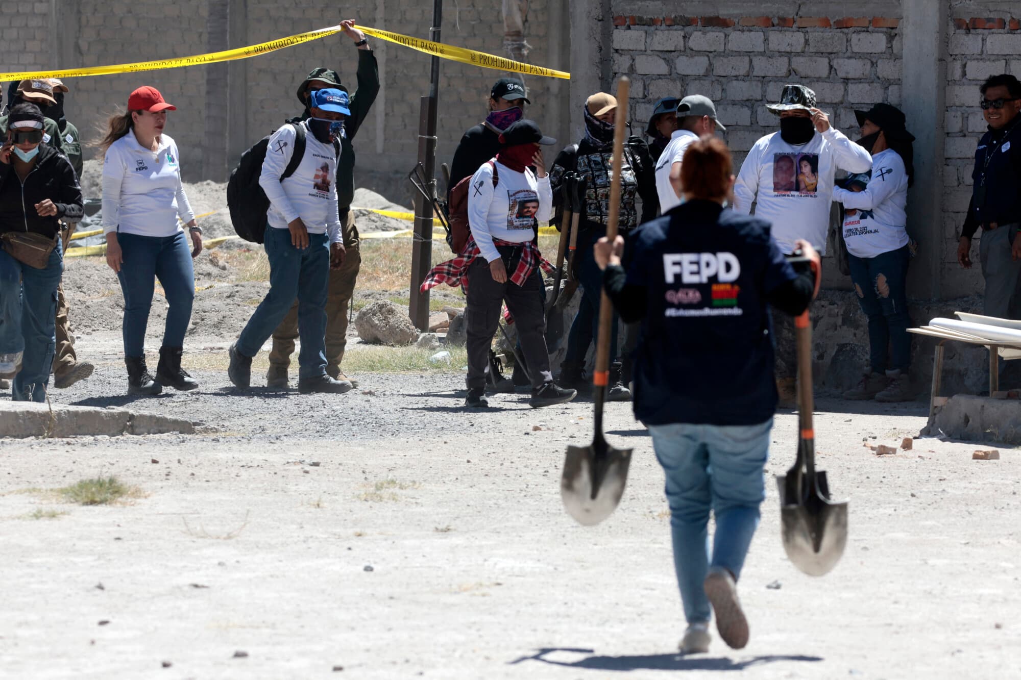 Un miembro de la Fiscalía Especial para Personas Desaparecidas lleva palas mientras miembros del colectivo "Guerreros Buscadores" visitan el rancho Izaguirre, donde el 5 de marzo localizaron tres hornos crematorios humanos mientras buscaban a sus familiares desaparecidos en la comunidad de La Estanzuela, en Teuchitlán, estado de Jalisco, México, el 13 de marzo de 2025. (ULISES RUIZ/AFP vía Getty Images)