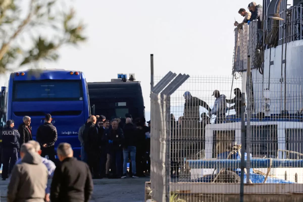<em>Migrantes procedentes de diversos centros de detención en Italia son escoltados por la policía al desembarcar de un buque de la Armada italiana en el puerto de Shengjin, Albania, el 11 de abril de 2025. (Adnan Beci/AFP vía Getty Images).</em>