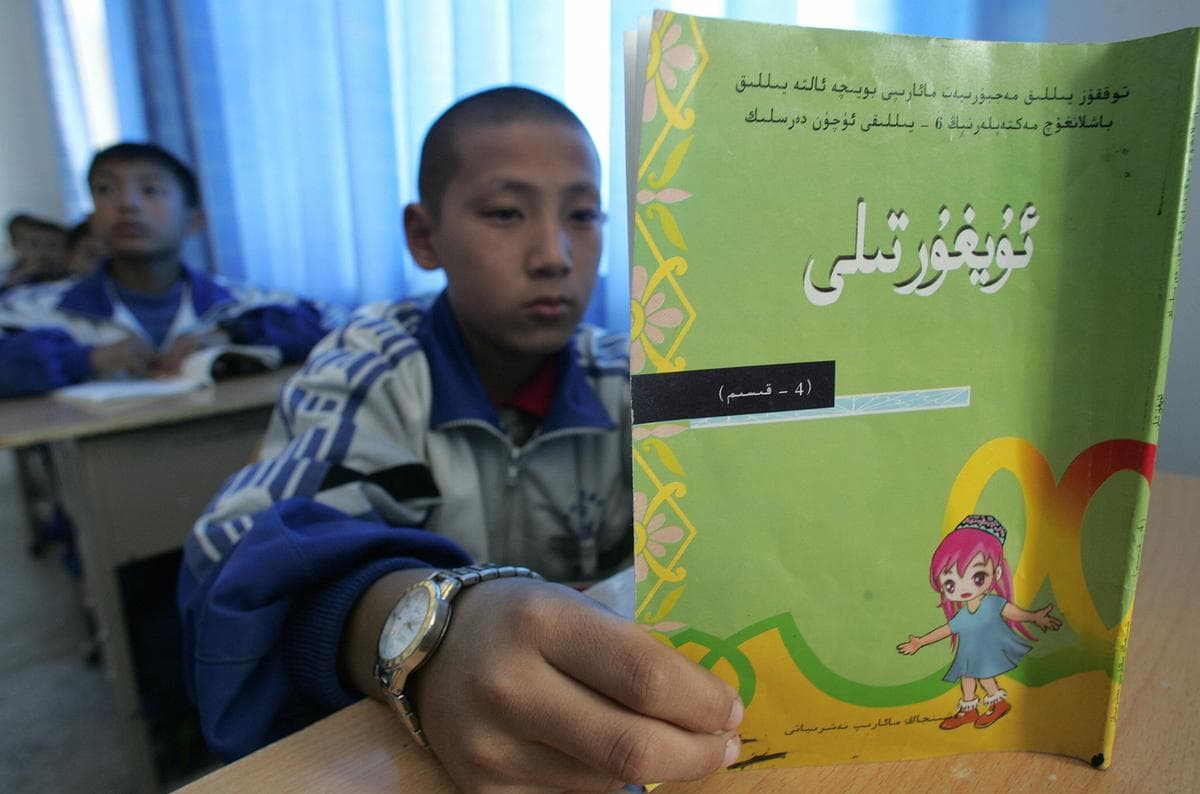 Un alumno lee sus lecciones en un aula de un instituto bilingüe para alumnos musulmanes de etnia uigur y chinos han en Hotan, Xinjiang, el 13 de octubre de 2006. (Frederic J. Brown/AFP vía Getty Images).
