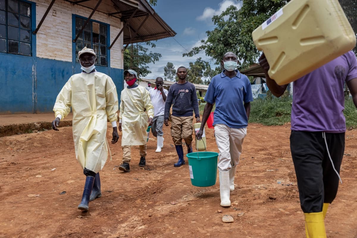 <em>Trabajadores sanitarios y voluntarios locales transportan contenedores de desinfectante y equipos de saneamiento en las afueras del Hospital General de Referencia en Mongbwalu, Congo, el 21 de mayo de 2026. (Michel Lunanga / Getty Images).</em>