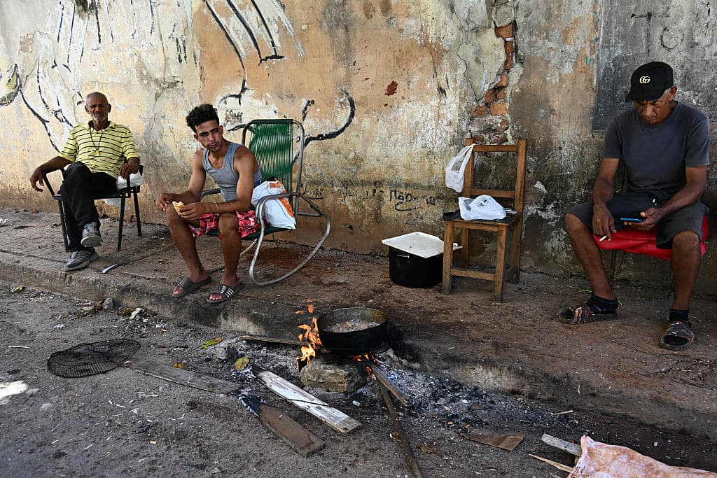 La gente cocina con leña en la calle durante un apagón en La Habana, el 7 de julio de 2026.(YAMIL LAGE / AFP vía Getty Images)