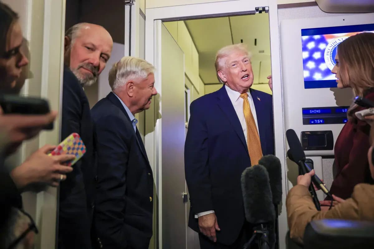 El presidente Donald Trump, el secretario de Comercio Howard Lutnick (izquierda) y el senador Lindsey Graham (R-S.C.) (centro) hablan con los medios de comunicación a bordo del Air Force One de camino a Washington el 4 de enero de 2026. (Joe Raedle/Getty Images)