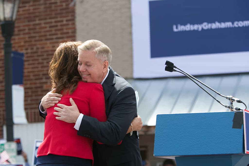 El senador estadounidense Lindsey Graham (R-SC) abraza a su hermana Darline Graham Nordone en el escenario mientras anuncia su candidatura a la presidencia de Estados Unidos durante un evento al aire libre para sus seguidores en Central, Carolina del Sur, el 1 de junio de 2015. (Jessica McGowan/Getty Images)