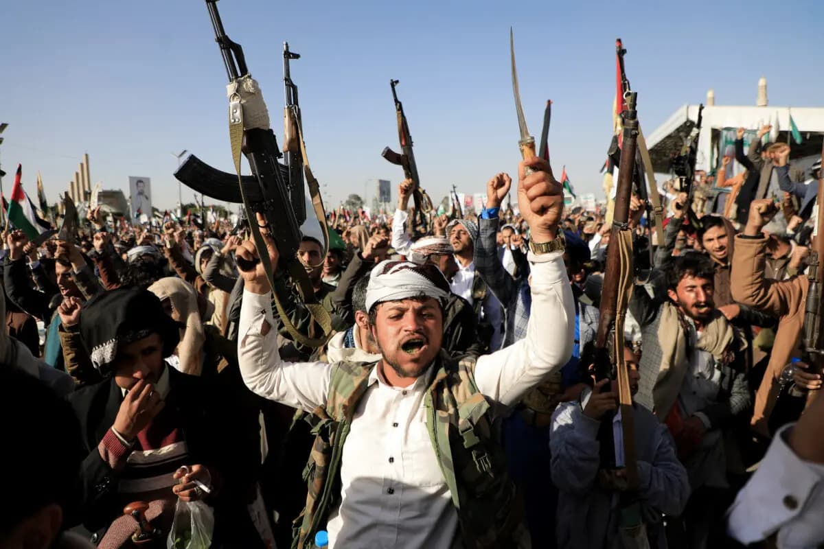 Combatientes hutíes blanden sus armas durante una protesta tras los ataques de las fuerzas estadounidenses y británicas en Saná, la capital controlada por los hutíes, el 12 de enero de 2024. (Mohammed Huwais/AFP vía Getty Images).