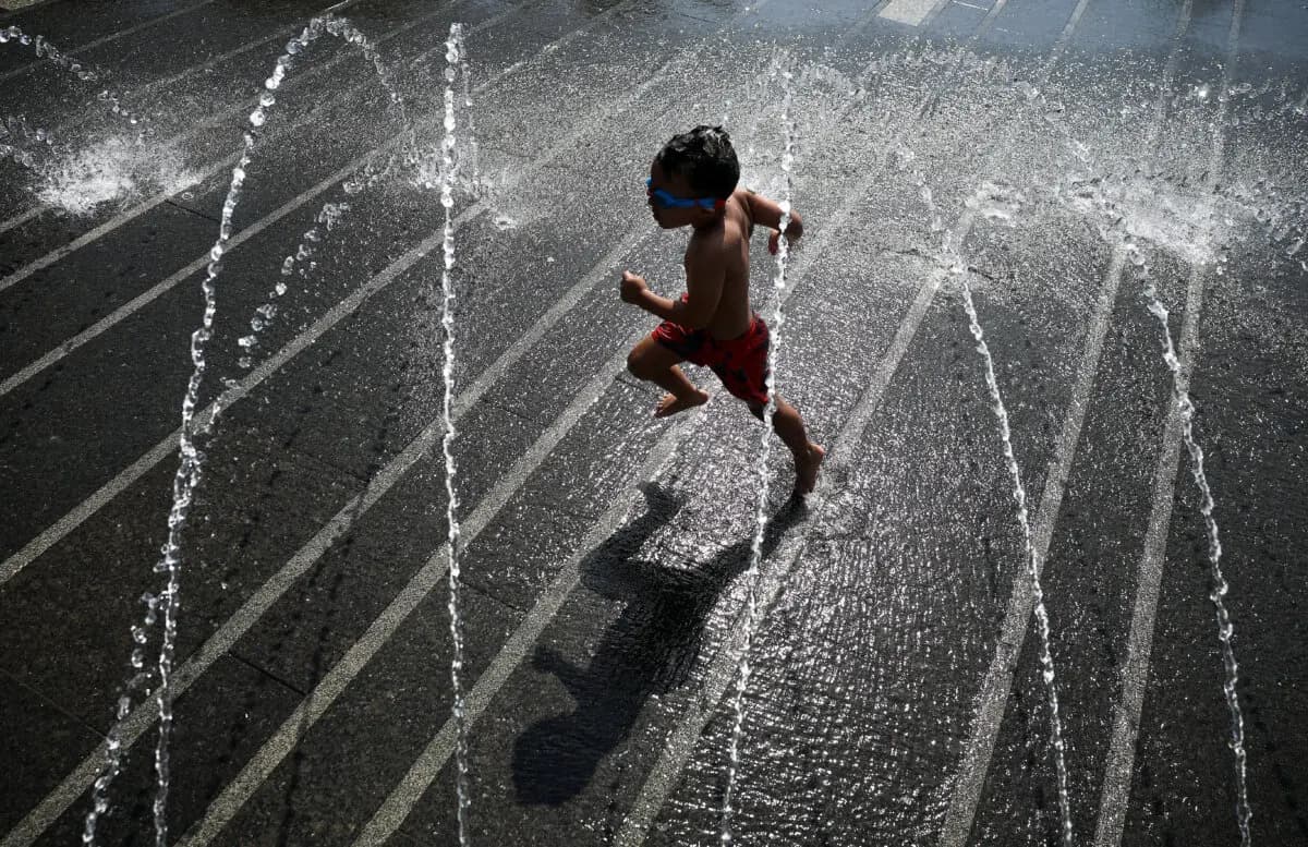 Un niño se refresca en una fuente en el Georgetown Waterfront Park de Washington el 2 de julio de 2026. (Kevin Dietsch/Getty Images)