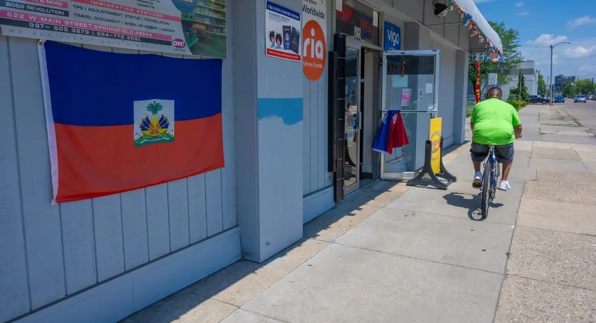 Un ciclista pasa junto a la bandera haitiana que cuelga de la pared del Creation Market, en la calle West Main de Springfield, Ohio, el 3 de julio de 2026. (Glenn Hartong para The Epoch Times).
