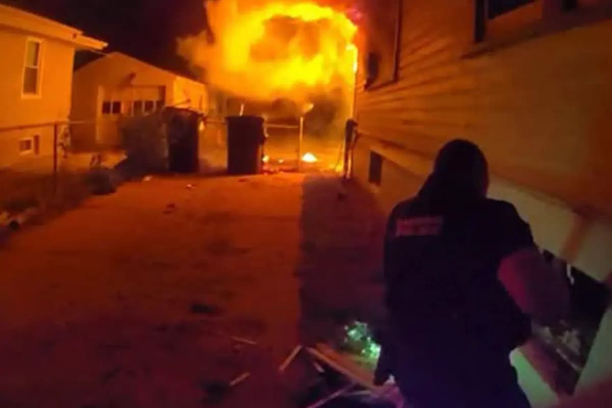 <em>Las imágenes de la cámara corporal muestran al oficial David Eckstrom ayudando a un niño a escapar de un incendio en una casa por la ventana del sótano. (Departamento de Policía de Omaha).</em>