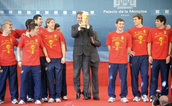 El presidente del Gobierno español, José Luis Rodríguez Zapatero (C), salta con el trofeo junto a los jugadores españoles durante una recepción en el Palacio de la Moncloa el 12 de julio de 2010 en Madrid, un día después de ganar la Copa del Mundo por primera vez tras la victoria por 1-0 contra Holanda. (ANDER GILLENEA / AFP vía Getty Images)