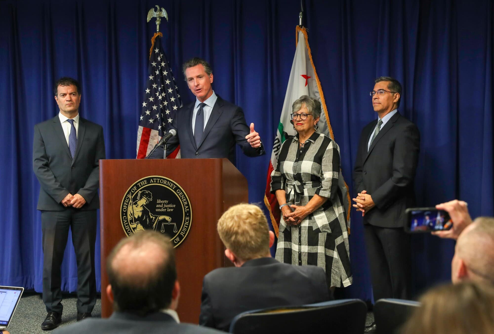 El gobernador de California, Gavin Newsom (C), interviene mientras el secretario de la Agencia de Protección Ambiental de California, Jared Blumenfeld (I), la presidenta de la Junta de Recursos del Aire de California, Mary Nichols (2.ª por la derecha), y el fiscal general de California, Xavier Becerra (D), observan durante una rueda de prensa sobre los cambios introducidos por la Administración Trump en las normas de emisiones de los vehículos, celebrada en Sacramento, California el 18 de septiembre de 2019. (Justin Sullivan/Getty Images).