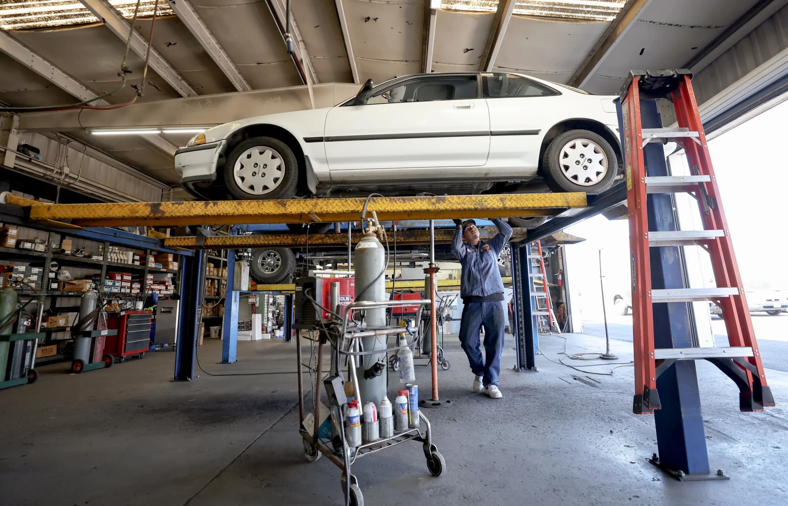Un mecánico trabaja en un auto en un taller de San Rafael, California, el 11 de julio de 2022. Una nota reciente del presidente Donald Trump tiene como objetivo facilitar el acceso a las reparaciones de vehículos en el mercado de repuestos, concretamente en lo que respecta a los sistemas de emisiones de los automóviles. (Justin Sullivan/Getty Images).