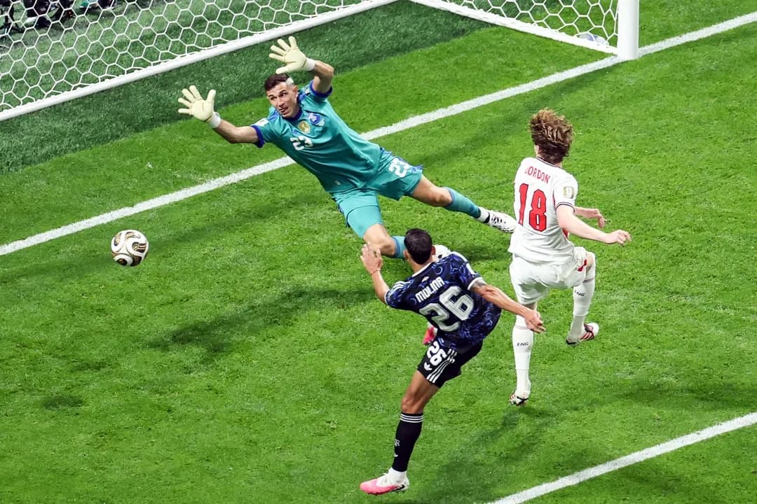 El delantero inglés n.º 18, Anthony Gordon, anota el primer gol de su equipo al superar al portero argentino n.º 23, Emiliano Martínez, durante el partido de semifinales del Torneo Mundial de Fútbol de 2026 entre Inglaterra y Argentina, celebrado en el Estadio de Atlanta, en Atlanta, Georgia, el 15 de julio de 2026. (Patricia de Melo Moreira/AFP vía Getty Images)