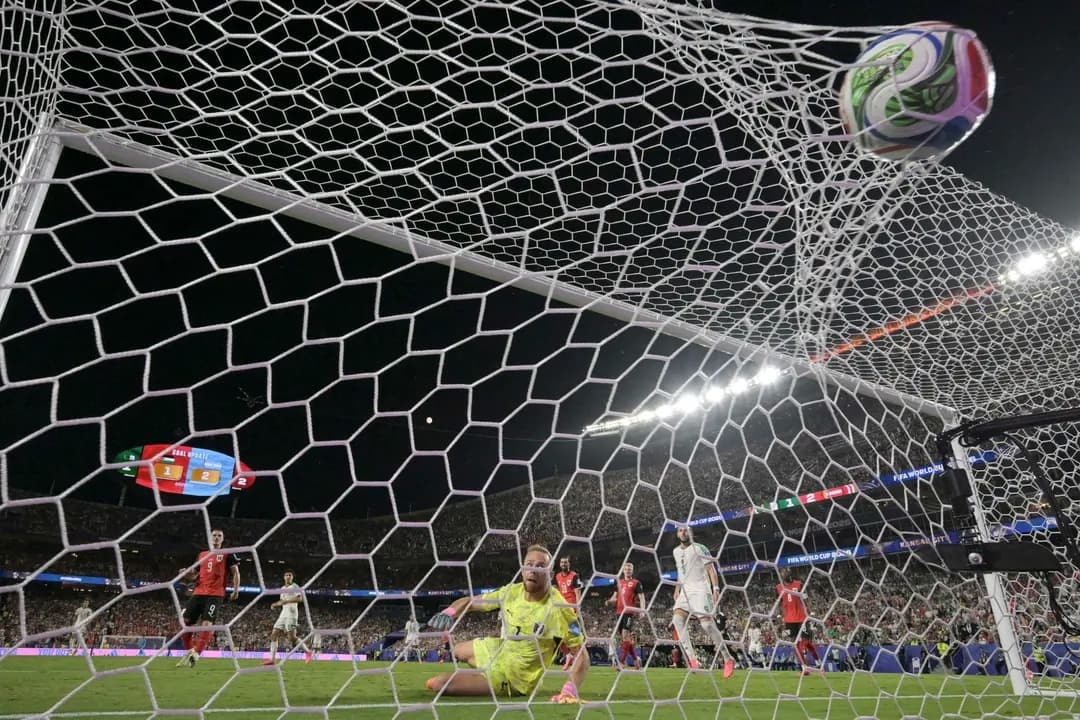 El portero n.º 1 de Austria, Alexander Schlager, observa el balón tras no poder detener un gol del delantero n.º 7 de Argelia, Riyad Mahrez, durante el partido de fútbol del Grupo J de la Copa Mundial de 2026 entre Argelia y Austria, en el Kansas City Stadium de Kansas City, Missouri, el 27 de junio de 2026. (Juan Mabromata/AFP vía Getty Images)