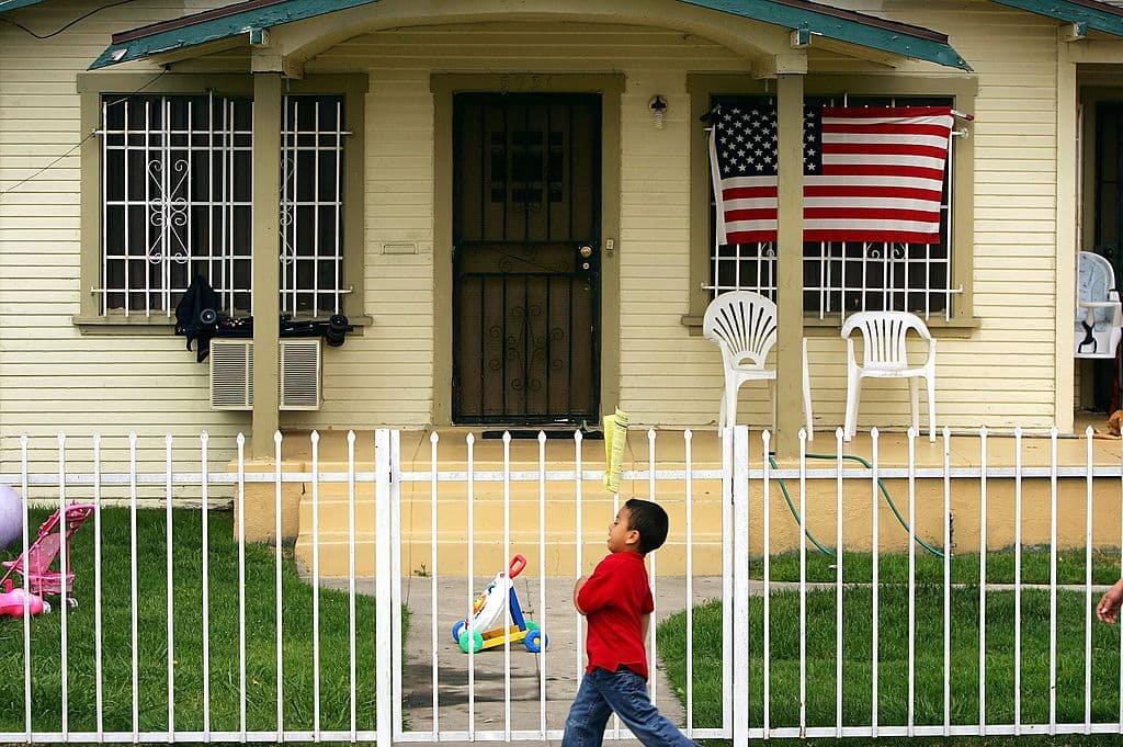 <em>Una bandera estadounidense cuelga de una casa unifamiliar en un vecindario latino el 17 de mayo de 2006 en la ciudad de Maywood, California, en el área de Los Ángeles, donde aproximadamente el 96 por ciento de los 29,000 residentes de la ciudad eran latinos. (Foto de David McNew/Getty Images)</em>