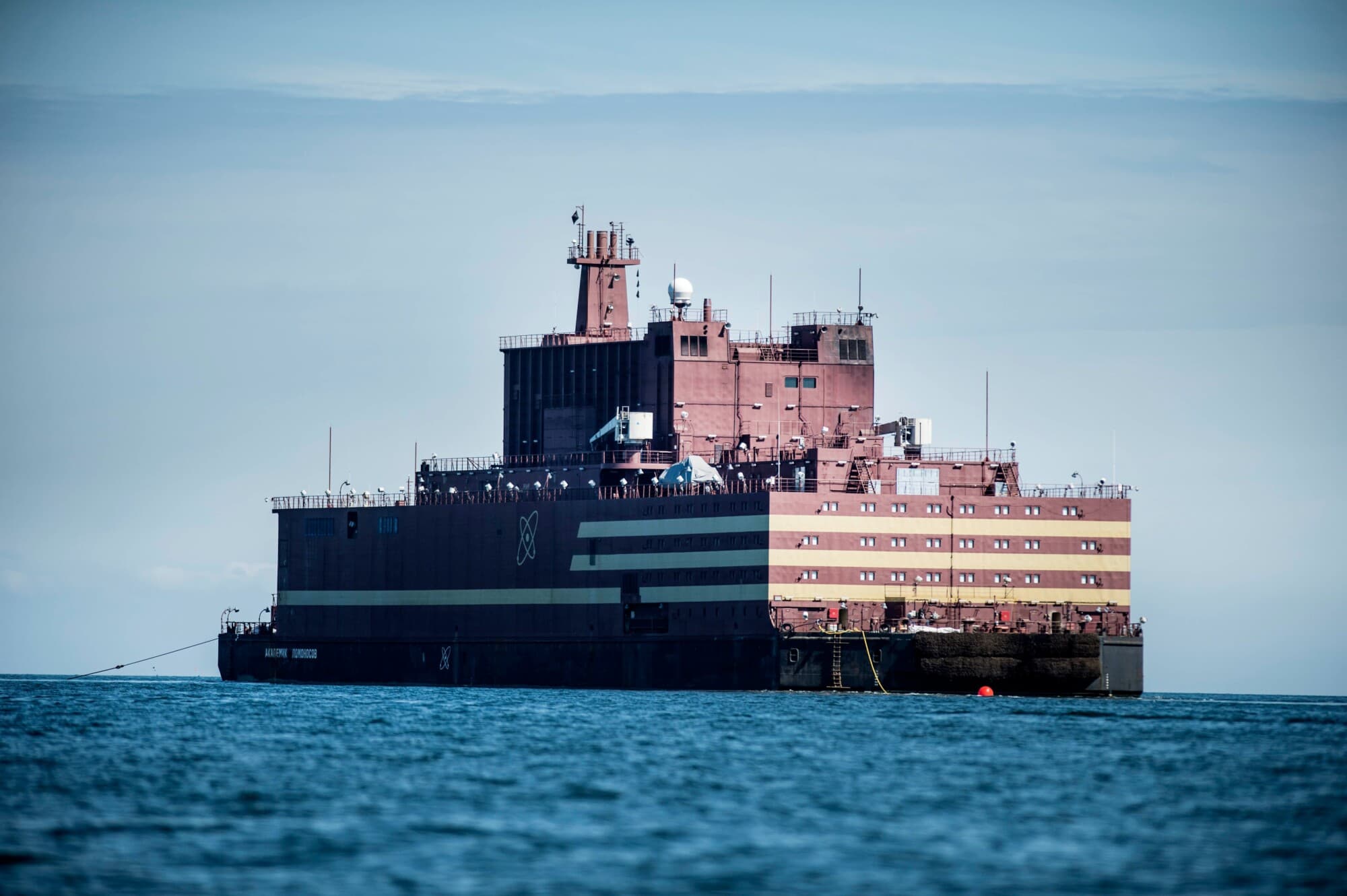 La primera central nuclear flotante del mundo, la rusa "Akademik Lomonosov", pasa junto a la isla de Langeland, frente a la costa de Spodsbjerg en Dinamarca, el 4 de mayo de 2018, mientras es remolcada por el mar Báltico hacia Murmansk. (Tim Kildeborg Jensen/AFP vía Getty Images).