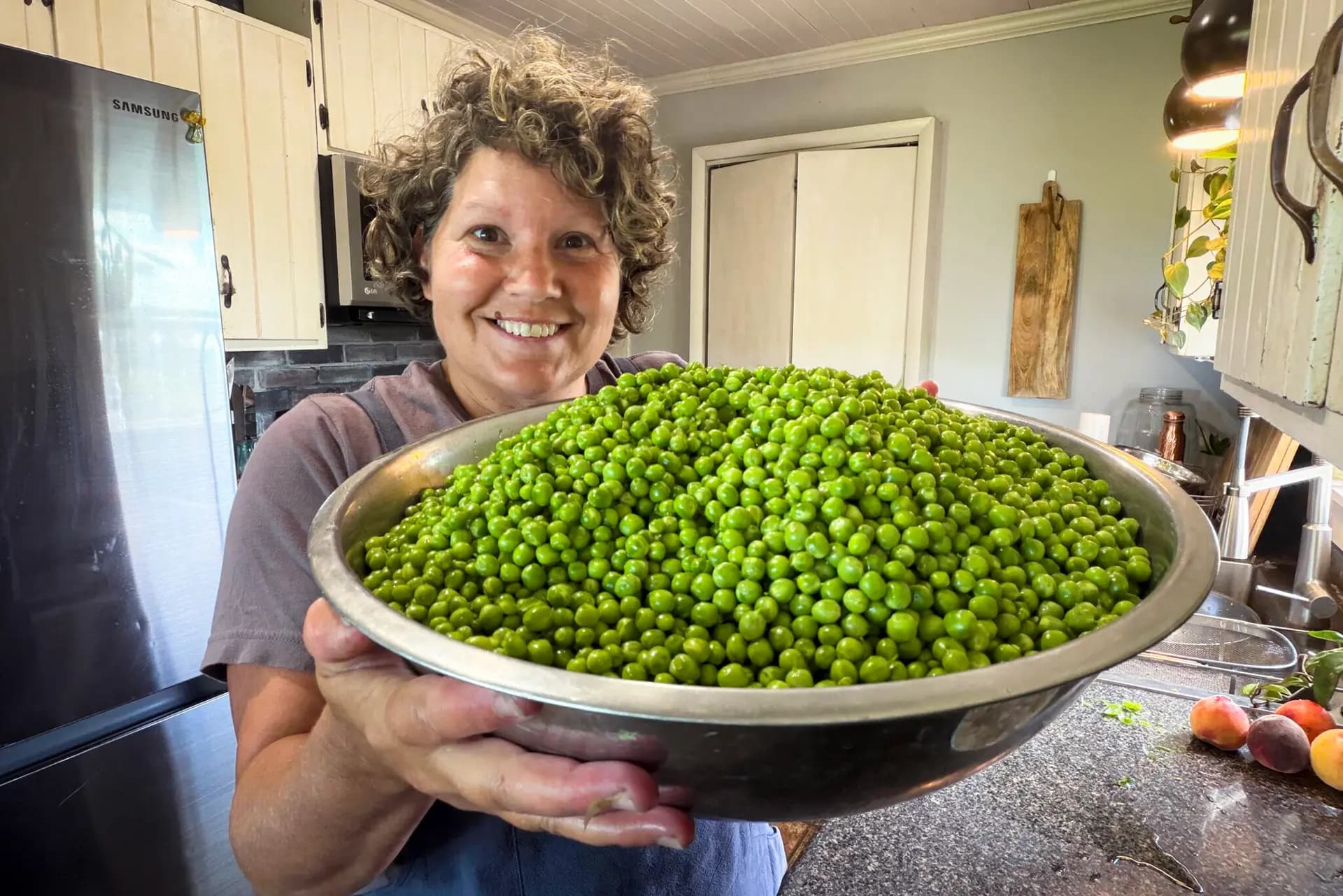 Ruth Ann Zimmerman muestra los chícharos que cosechó en la granja que administra junto a su esposo, Elvin, en el noreste de Iowa, en junio de 2026. Zimmerman es autora del libro “The Heart of the Homestead: Cultivating a Spirit of Simple Living Through Homemaking, Recipes, and Family” (El corazón de la granja: cómo cultivar un espíritu de vida sencilla a través de las tareas del hogar, las recetas y la familia). (Cortesía de Ruth Ann Zimmerman).