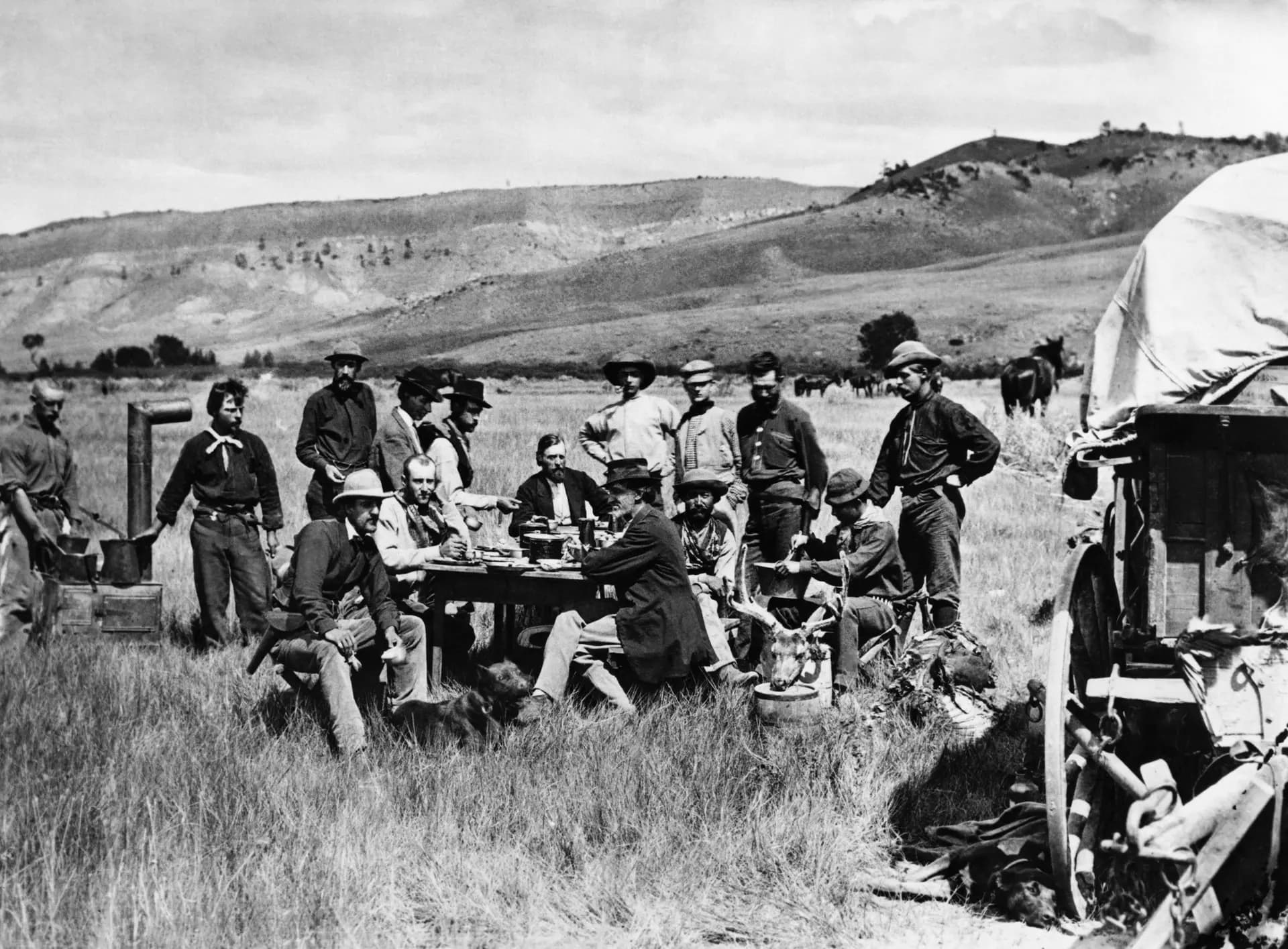 Miembros del Servicio Geológico de Estados Unidos, dirigido por Hayden, almuerzan en el campamento de Red Buttes, en el Territorio de Wyoming, el 24 de agosto de 1870. Sentado a la mesa, de cara a la cámara, se encuentra el geólogo Ferdinand Vandeveer Hayden; a la derecha está el fotógrafo oficial del servicio, William Henry Jackson. El grupo, liderado por Hayden, exploró la región del noroeste de Wyoming que más tarde se convertiría en el Parque Nacional de Yellowstone. (ACME / AFP vía Getty Images).