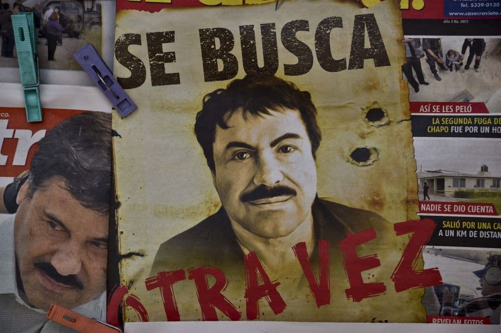 <em>Un cartel con el rostro del narcotraficante mexicano Joaquín "el Chapo" Guzmán y la frase "Se busca, otra vez" aparece en un puesto de prensa de una de las principales terminales de autobuses de la Ciudad de México el 13 de julio de 2015, un día después de que el gobierno informara de su fuga de una prisión de máxima seguridad. Las fuerzas de seguridad mexicanas desplegaron un operativo para recapturarlo mientras las autoridades investigaban si guardias penitenciarios lo habían ayudado a escapar a través de un túnel construido bajo su celda. (Yuri Cortez/AFP vía Getty Images)</em>