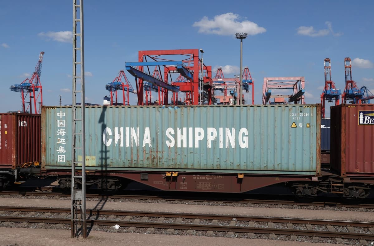 Contenedores de carga, incluido uno de China Shipping, yacen sobre vagones de plataforma mientras las grúas portuarias se alzan detrás en el puerto de Hamburgo, en Alemania, el 15 de abril de 2025. (Sean Gallup/Getty Images)
