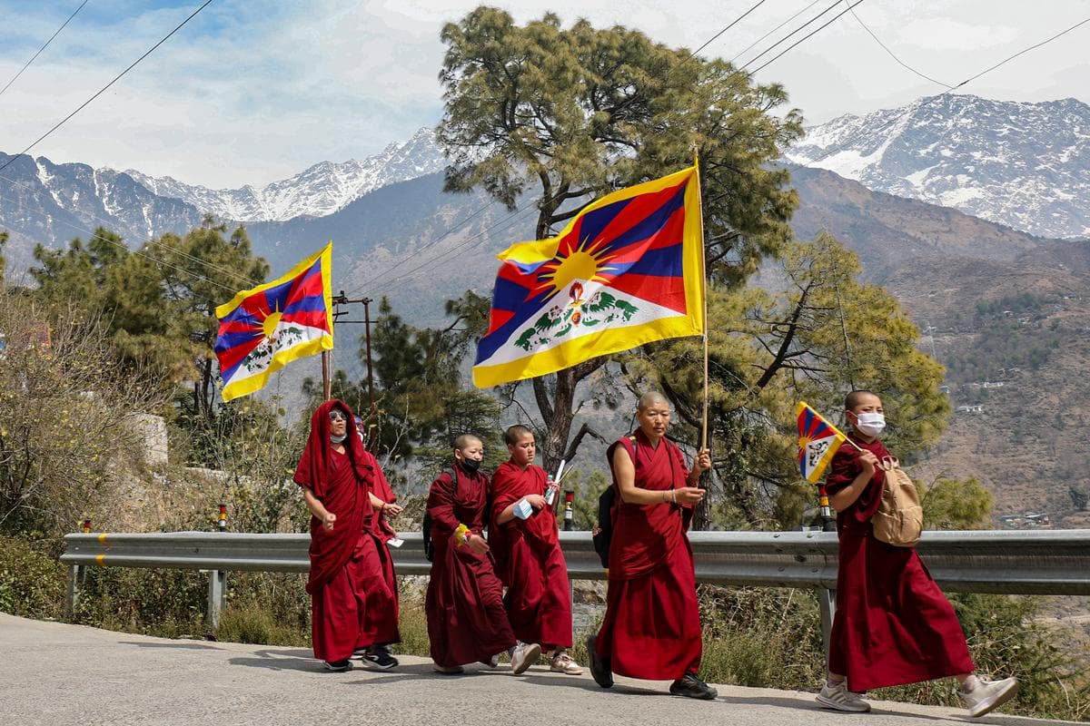 Monjes tibetanos que viven en el exilio en la India enarbolan banderas del Tíbet durante una marcha por la paz con motivo del 65.º aniversario del Levantamiento Nacional Tibetano contra la ocupación china del Tíbet, en el barrio de McLeod Ganj, cerca de Dharamshala, India, el 10 de marzo de 2024. (Sanjay Baid/AFP vía Getty Images).