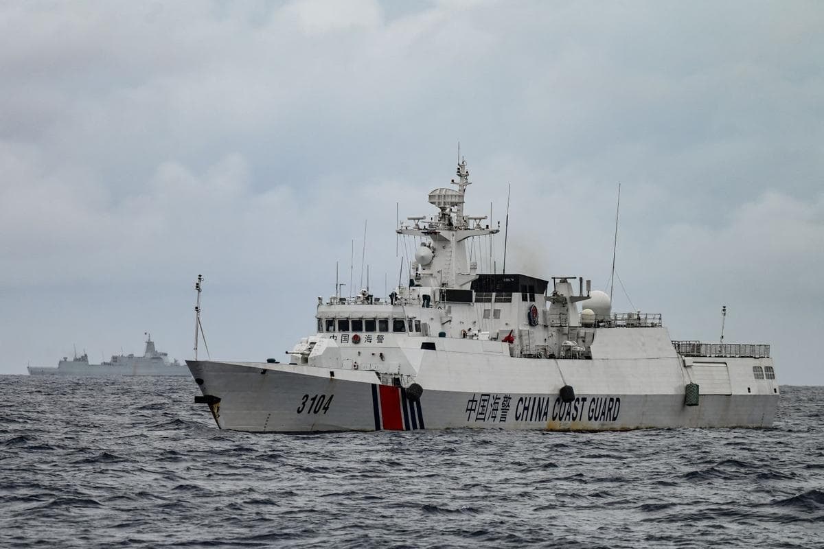 Desde el buque de la Guardia Costera de Filipinas BRP Cabra se observan un barco de la Guardia Costera china (a la derecha) y una embarcación identificada por la Guardia Costera de Filipinas como un buque de la Armada china (al fondo a la izquierda) durante una misión de abastecimiento en el banco de Sabina, en aguas en disputa del Mar de China del Sur, el 26 de agosto de 2024. (Jam Sta Rosa/AFP vía Getty Images)